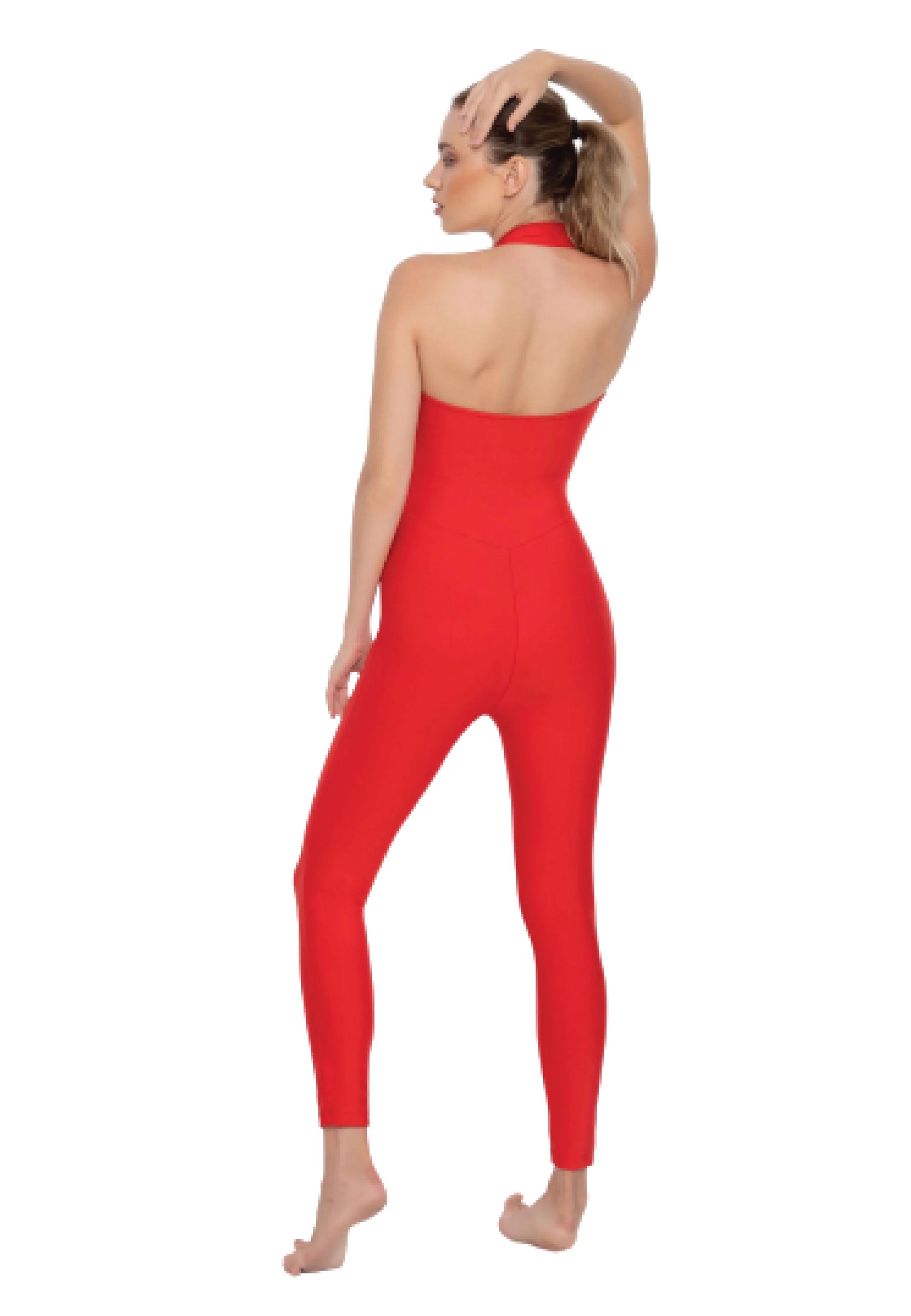 Barfüßige Person, die Esmeraldas Lucia-Jumpsuit in Rot trägt und mit einem Seitenblick vor einem weißen Hintergrund posiert.